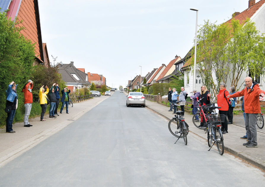 Fotografie - Teilnehmer_innen des Schwarzplanspaziergangs imitieren die verschiedenen Dachausrichtungen auf den beiden Strassenseiten der Breslauer Strasse